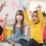 Preschool children engaged in a fun and interactive classroom activity, fostering participation through advanced education methods.