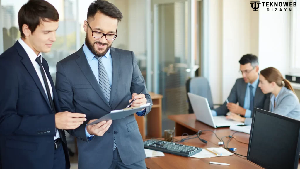 Two consultants discussing a project on a tablet in a bright office setting.