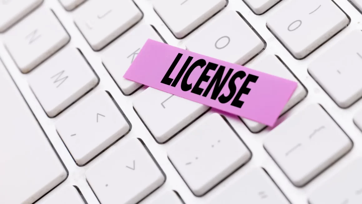 A keyboard with a sticky note reading 'LICENSE,' indicating the need for online license lookup services like MN educator license lookup.